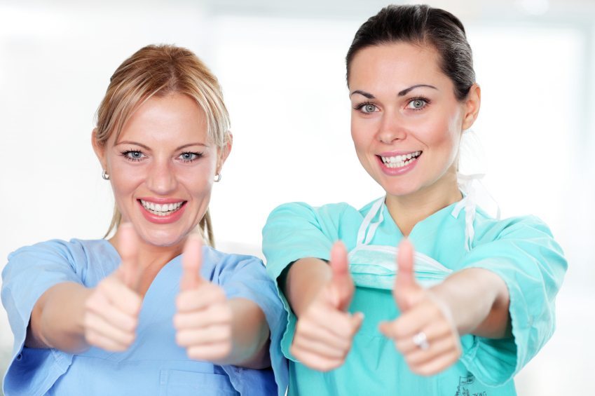 Beautiful medical nurses are showing okay with fingers.